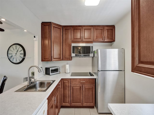 kitchen with appliances with stainless steel finishes, sink, and light tile patterned floors