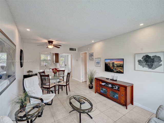 tiled living room featuring sink, a textured ceiling, and ceiling fan