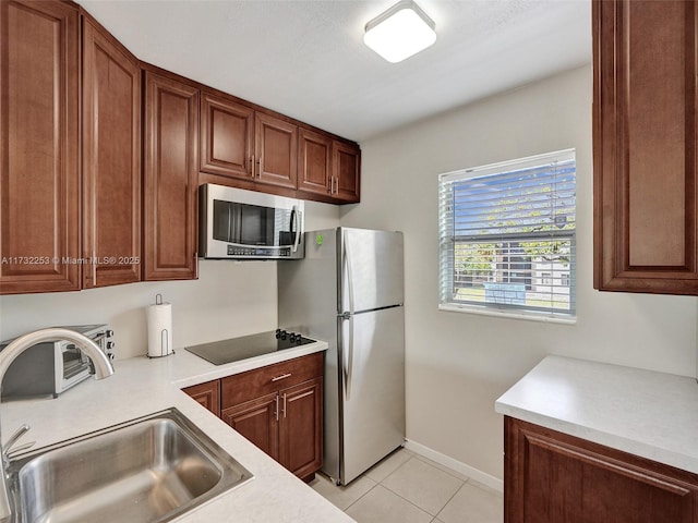 kitchen featuring sink, light tile patterned flooring, and appliances with stainless steel finishes