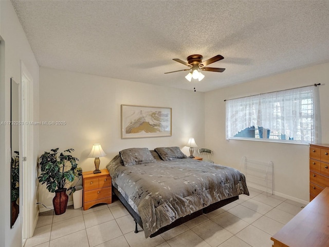 tiled bedroom featuring ceiling fan and a textured ceiling