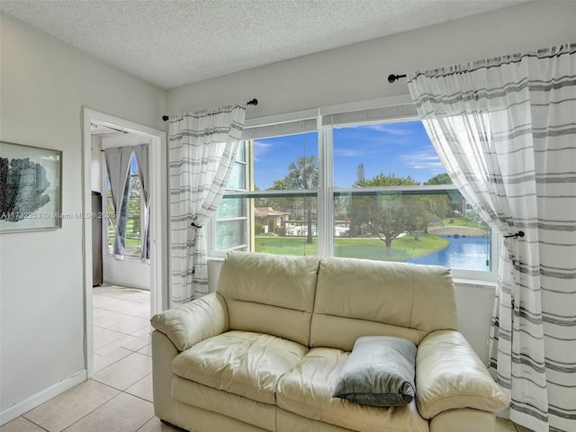 tiled living room with a water view and a textured ceiling