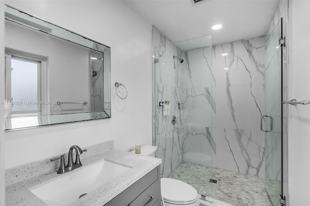 bathroom featuring walk in shower, vanity, and toilet