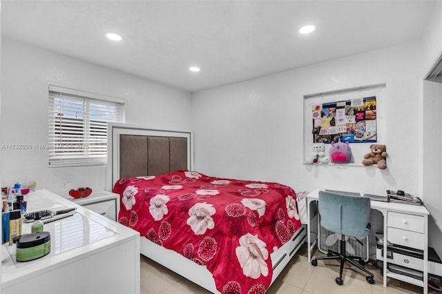 bedroom with a baseboard radiator and light tile patterned floors