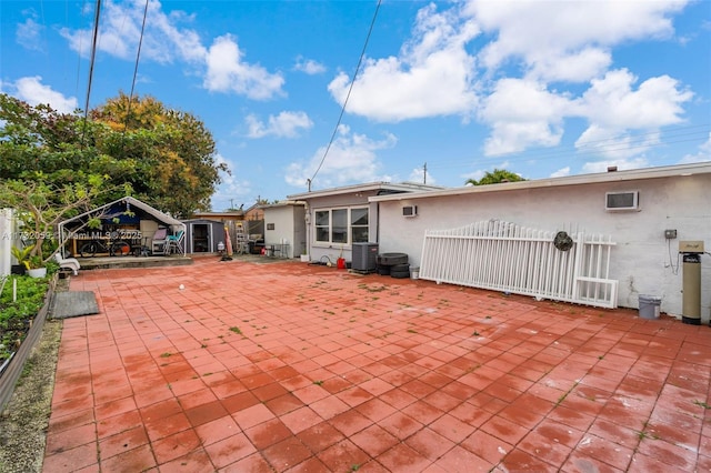 rear view of property with central AC unit and a patio area