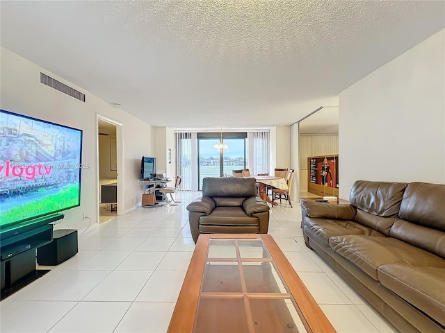 living room with floor to ceiling windows, light tile patterned floors, and a textured ceiling