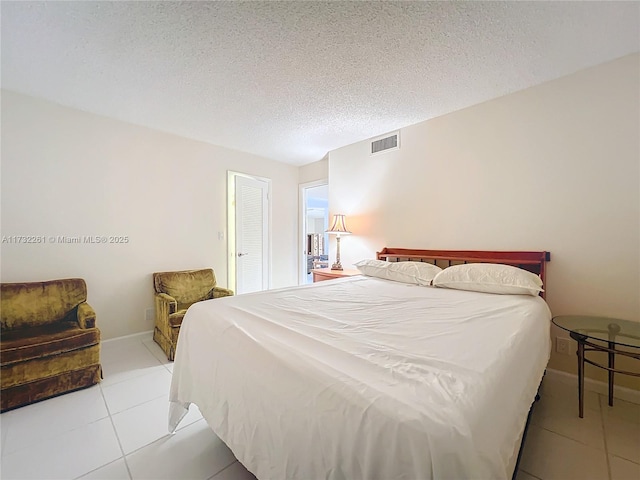 bedroom with light tile patterned floors and a textured ceiling