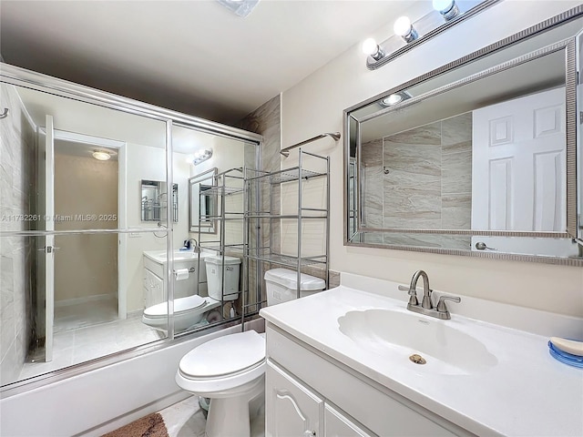 full bathroom featuring vanity, bath / shower combo with glass door, and toilet