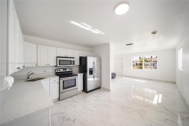 kitchen featuring white cabinetry, sink, and appliances with stainless steel finishes