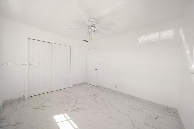 unfurnished bedroom with ceiling fan and a closet