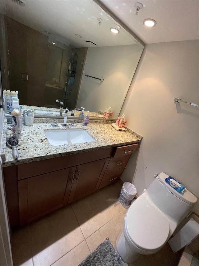 bathroom with tile patterned floors, toilet, a shower with door, and vanity