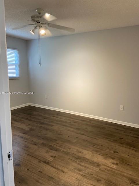 empty room with a textured ceiling, dark hardwood / wood-style floors, and ceiling fan