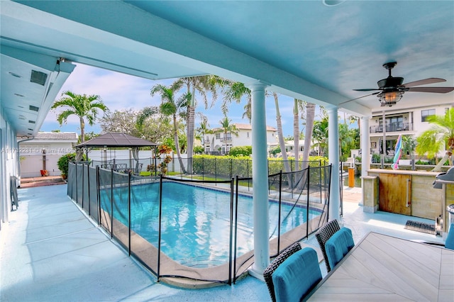 view of pool featuring a gazebo, a patio area, ceiling fan, and exterior bar