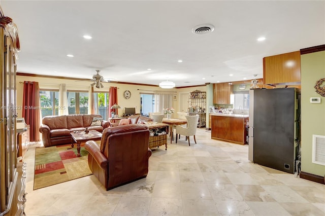 living room featuring crown molding and ceiling fan