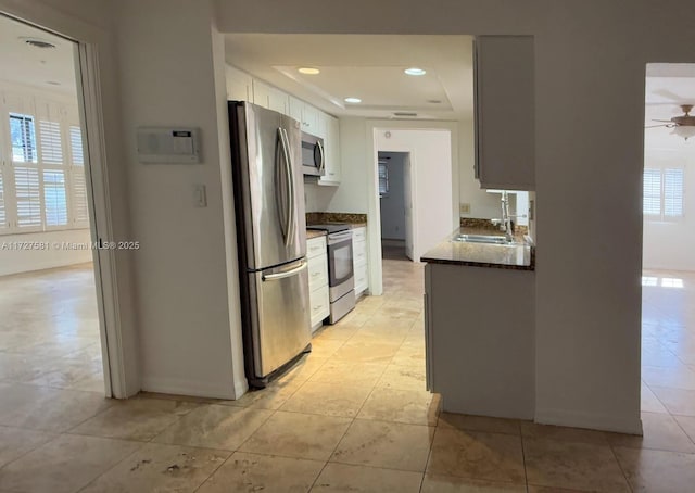 kitchen featuring white cabinets, a ceiling fan, stainless steel appliances, a sink, and recessed lighting