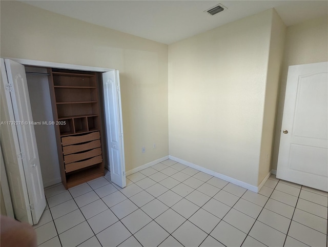 unfurnished bedroom featuring light tile patterned floors and a closet