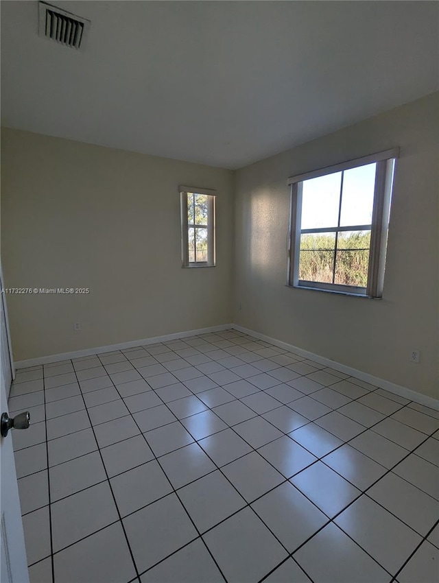 unfurnished room featuring light tile patterned flooring and a healthy amount of sunlight