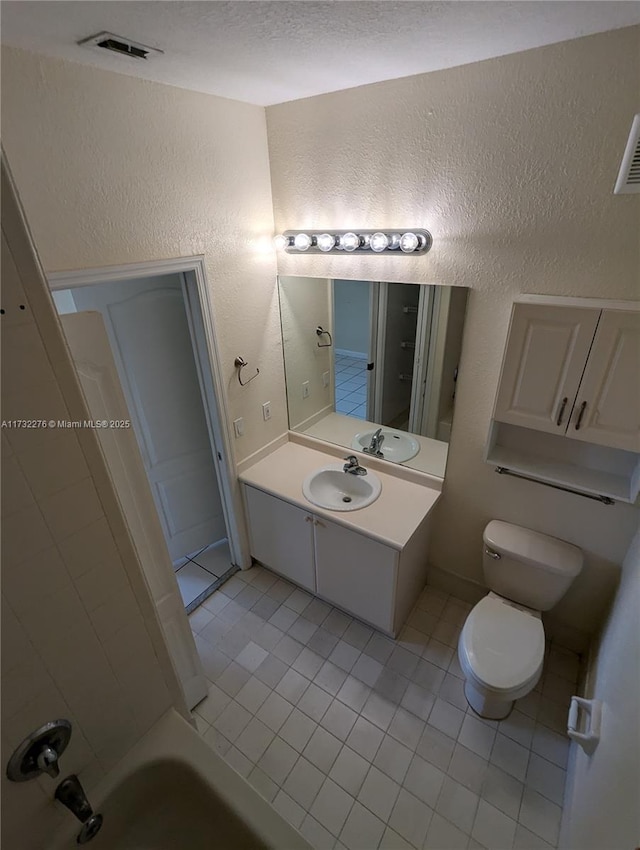 bathroom featuring tile patterned floors, toilet, vanity, and a textured ceiling