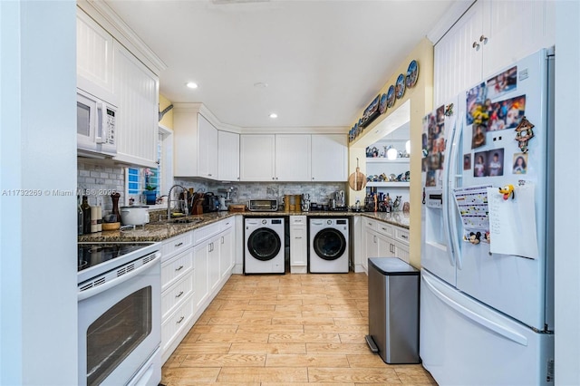 kitchen with white appliances, white cabinetry, and dark stone countertops