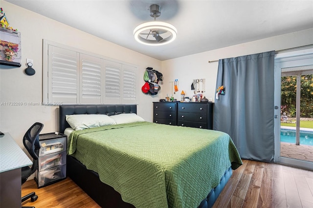 bedroom with wood-type flooring and access to exterior