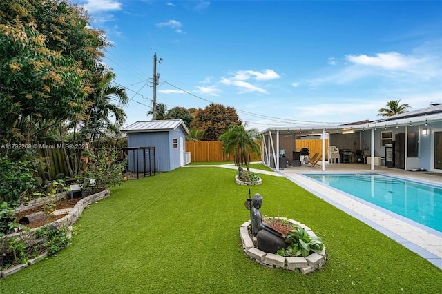 view of yard with a storage unit, a fenced in pool, and a patio area