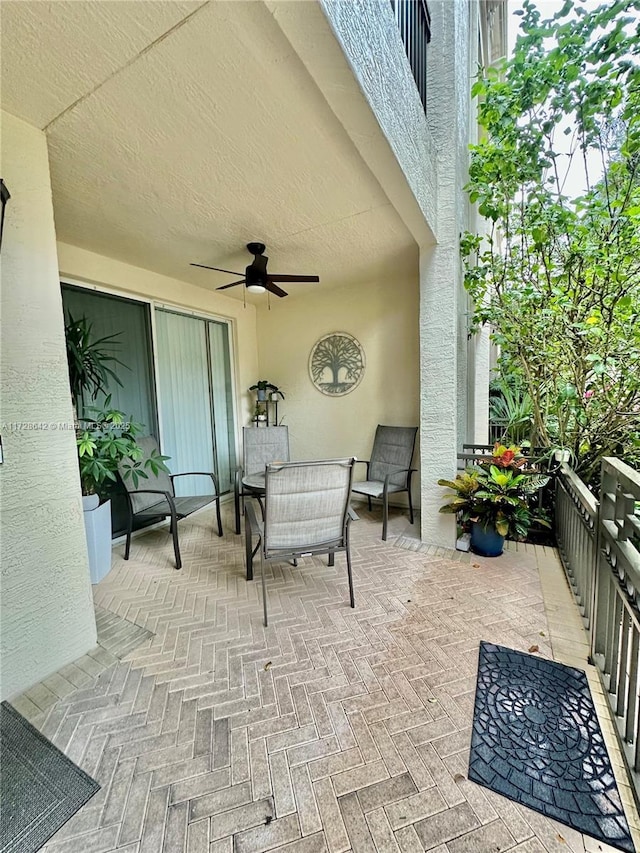 view of patio featuring ceiling fan and a balcony