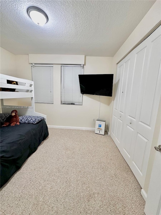 bedroom featuring a closet, carpet, and a textured ceiling