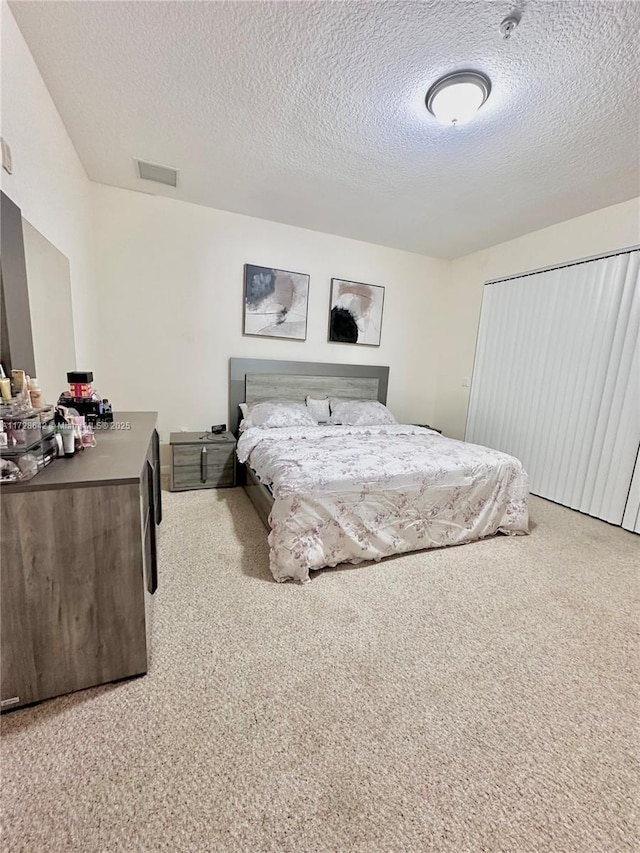 carpeted bedroom featuring a textured ceiling