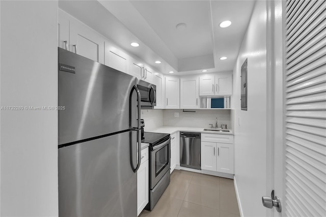 kitchen featuring light tile patterned flooring, appliances with stainless steel finishes, sink, and white cabinets