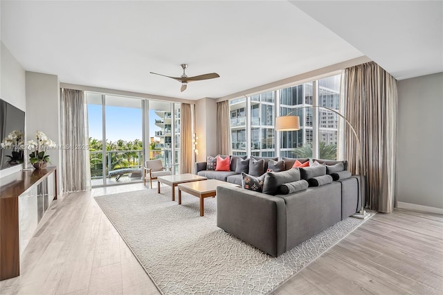 living room featuring floor to ceiling windows, a wealth of natural light, ceiling fan, and light hardwood / wood-style flooring