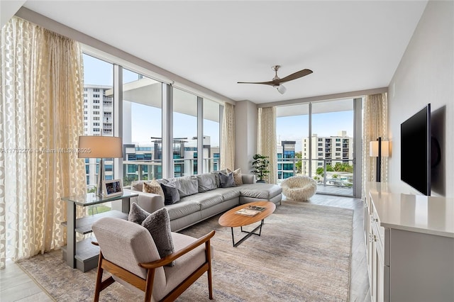 living room featuring expansive windows, light tile patterned floors, and ceiling fan