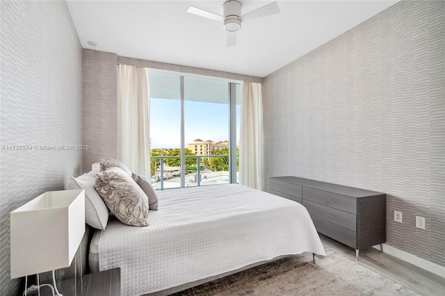 bedroom featuring ceiling fan, light hardwood / wood-style floors, and access to outside