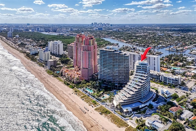 birds eye view of property with a water view and a beach view