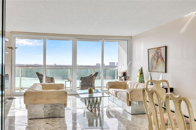 living room featuring a water view, expansive windows, and a textured ceiling