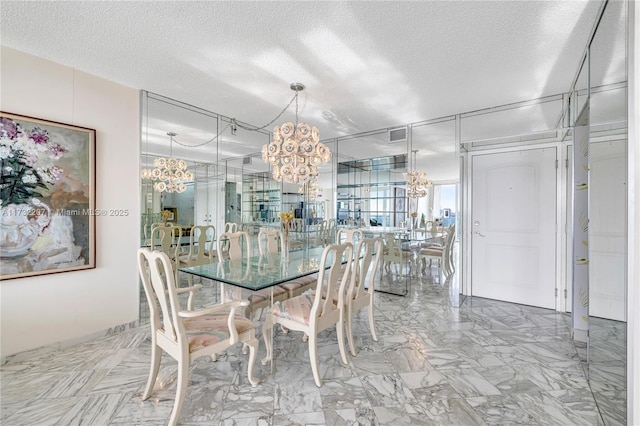 dining room featuring an inviting chandelier and a textured ceiling