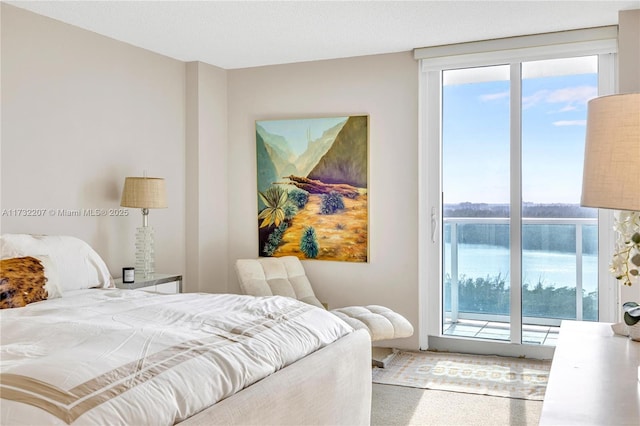 carpeted bedroom featuring a water view and access to outside