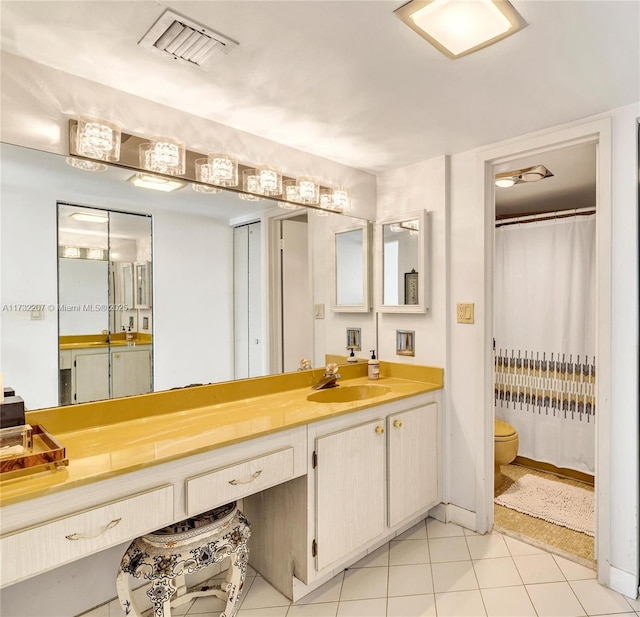 bathroom featuring vanity, tile patterned floors, and toilet