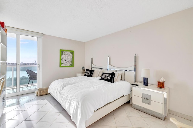 tiled bedroom with access to exterior and a textured ceiling