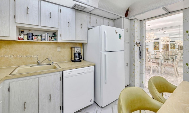 kitchen featuring tasteful backsplash, sink, white appliances, and a notable chandelier