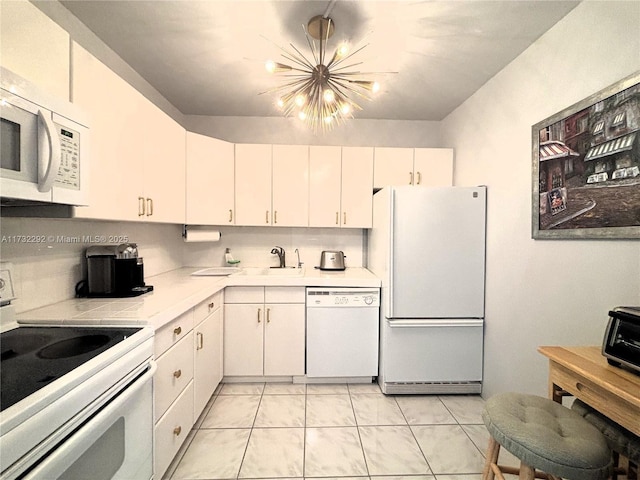 kitchen featuring tasteful backsplash, sink, white cabinets, a notable chandelier, and white appliances