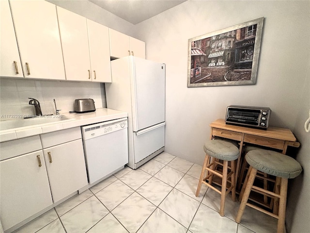 kitchen featuring white cabinetry, sink, white appliances, and light tile patterned flooring