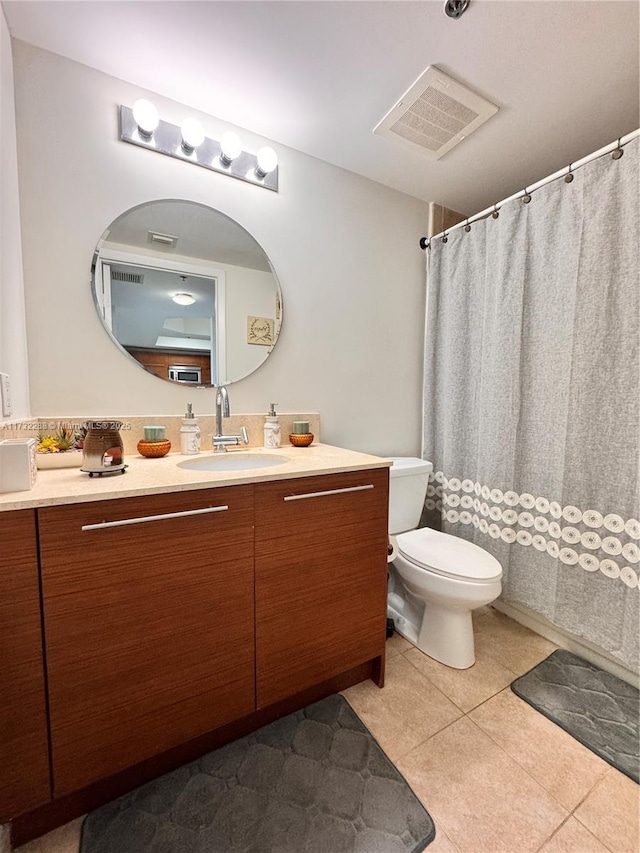 bathroom featuring vanity, toilet, and tile patterned flooring