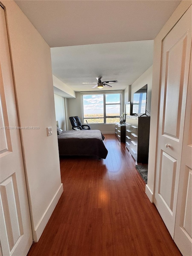 bedroom with dark hardwood / wood-style floors and ceiling fan