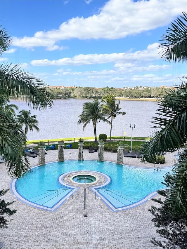 view of swimming pool with a water view, pool water feature, and a community hot tub