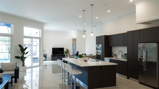 kitchen with sink, decorative light fixtures, dark brown cabinets, a kitchen island, and stainless steel appliances