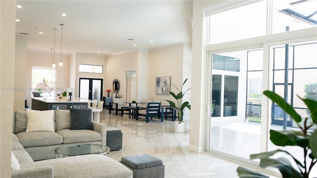 living room with crown molding, french doors, and a towering ceiling