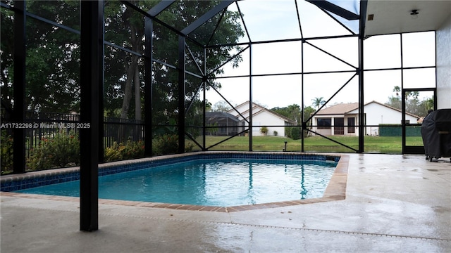 view of swimming pool featuring a patio, glass enclosure, and a lawn