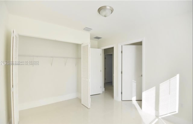 unfurnished bedroom featuring a closet and light tile patterned floors