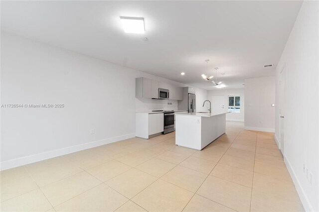 2555 NE 193rd St Unit 2102, Miami, FL 33180 - kitchen with appliances with stainless steel finishes, pendant lighting, sink, light tile patterned floors, and a center island with sink