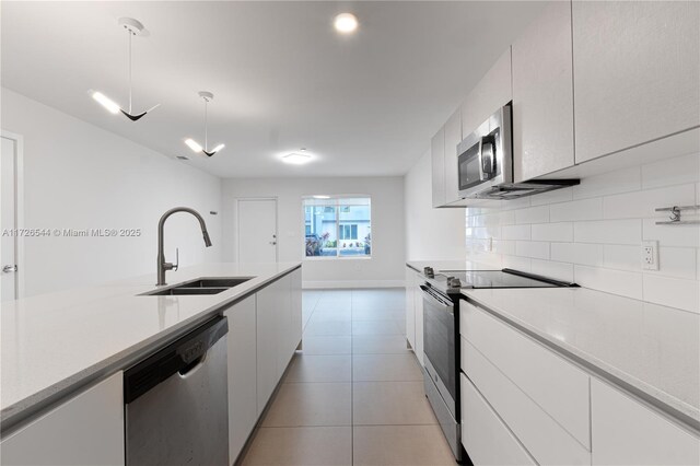 2555 NE 193rd St Unit 2102, Miami, FL 33180 - kitchen featuring sink, white cabinetry, hanging light fixtures, stainless steel appliances, and decorative backsplash