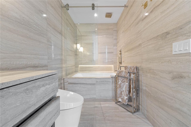 bathroom featuring vanity, tiled bath, and tile walls